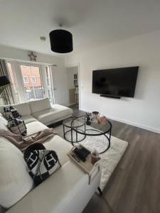 a living room with a couch and a flat screen tv at Beautiful apartment in Chichester