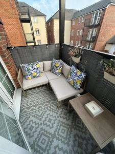 a patio with a couch and pillows on a balcony at Beautiful apartment in Chichester