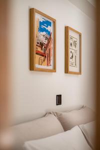 two pictures hanging on a wall above a bed at Atherial Studio in Athens