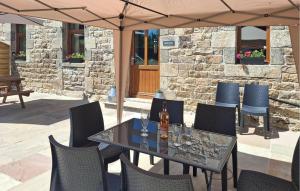 - une table et des chaises sous un parasol sur la terrasse dans l'établissement Ravissante Maison Bretonne, à Louargat