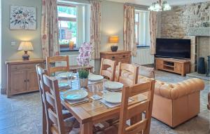 une salle à manger avec une table, des chaises et une télévision dans l'établissement Ravissante Maison Bretonne, à Louargat