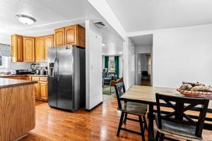 Una cocina con una mesa y un refrigerador de acero inoxidable. en Rancho Verde, en Pueblo 24 fotos más