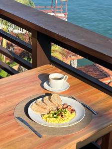 a plate of eggs and toast and a cup of coffee at Morada das marés in Angra dos Reis
