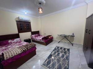 ein Zimmer mit zwei Betten und einem Tisch darin in der Unterkunft Burg Hotel in Burj al ‘Arab al Jadīdah