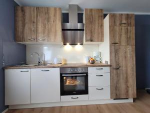 a kitchen with white cabinets and a stove top oven at Haus Valentonio in Zeltingen-Rachtig