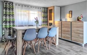 a dining room with a table and blue chairs at Amazing Home In Brodnica Górna in Brodnica Dolna