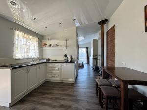 a kitchen with white cabinets and a wooden floor at Tac Premier in Ventspils