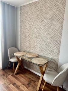 a glass table and two chairs in a room at Квартира на березі Дніпра у новому будинку! in Cherkasy