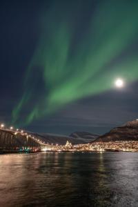 an aurora over a bridge over the water at night at Apartment in Tromsø in Tromsø