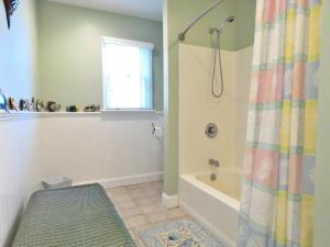 La salle de bains est pourvue d'une baignoire et d'un rideau de douche. dans l'établissement Cedar Cottage, à Cape May Point 20 autres photos
