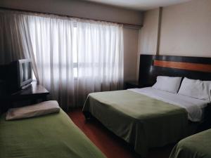 ブエノスアイレスにあるAl Porteñoのベッド2台とテレビがあるホテルの部屋 +12枚の写真