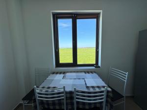 Zimmer mit einem Tisch mit Stühlen und einem Fenster in der Unterkunft Luna 21 Eforie Nord in Eforie