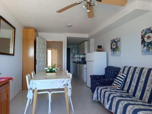a living room with a table and a couch at Apartamentos GEMA Primera linea Cullera in Cullera +28 photos