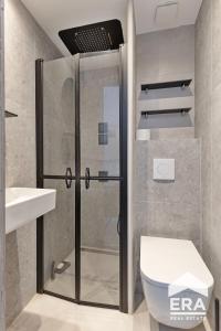 a bathroom with a shower and a toilet and a sink at Studio Cosy & Zen à Coxyde Dog-friendly in Koksijde