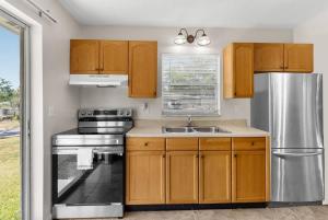 a kitchen with wooden cabinets and a stainless steel refrigerator at Cozy 2 Bedroom home, Dade City! #1 in Dade City