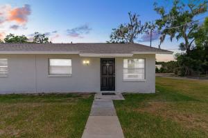 a white house with a door in a yard at Cozy 2 Bedroom home, Dade City! #1 in Dade City