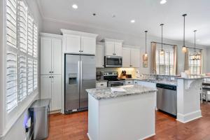 una cucina con armadietti bianchi ed elettrodomestici in acciaio inossidabile di Garden Cottage 71 a Jekyll Island