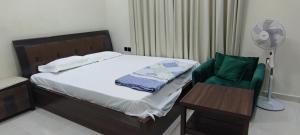 a bedroom with a bed and a chair and a fan at Villa 6 in Ajman 