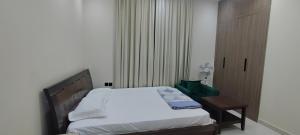 a small bedroom with a bed and a table at Villa 6 in Ajman 