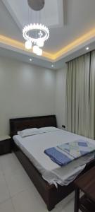 a bedroom with a bed and a chandelier at Villa 6 in Ajman 