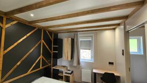 a room with a bed and a desk and a window at Coqslitscaux in Colleville