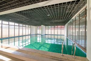 a large swimming pool with green water in a building at Leshwa House 1 in Nairobi