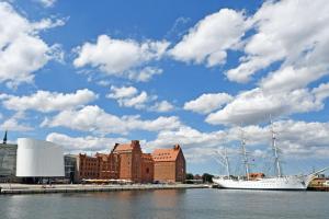 a sail boat in the water next to a city at Ferienwohnungen auf Rügen und nahe Stralsund in Poppelvitz +93 photos