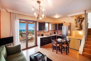 a kitchen and living room with a table and a dining room at Villa Anna Nikitas by Villa Plus in Agios Nikitas
