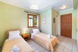 two beds in a room with green walls at Villa Anna Nikitas by Villa Plus in Agios Nikitas +11 photos