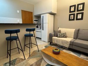 a living room with a couch and two bar stools at Rio das Pedras Loft in São Carlos