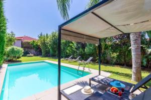 a pool with an umbrella and a table and chairs at Villa Thimari by Villa Plus in Melidhónion