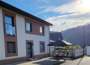 a house with a patio with a table and an umbrella at Haus Valentonio in Zeltingen-Rachtig