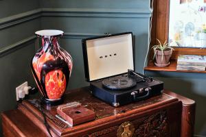 a table with a vase and a clock and aeper at Carnbore House BnB in Bushmills