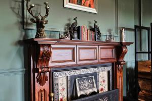 a wooden fireplace with a shelf on top of it at Carnbore House BnB in Bushmills