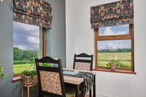a dining room with a table and two chairs and a window at Carnbore House BnB in Bushmills
