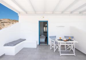 a white patio with a table and chairs at Vista Del Mar Milos in Agia Kiriaki Beach