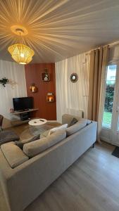 a living room with a couch and a chandelier at DaxLodge T3 cosy in Dax