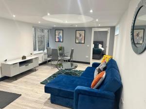 a living room with a blue couch and a dining room at The Lucia Apartments II - 1 Bedroom Town Centre Apartment - Contractor Friendly - Free Parking - Full Kitchen - Washer Dryer - Spacious - Ideal for Work Stays in Huntingdon