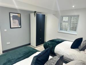 a bedroom with two beds and a cat picture on the wall at 1 Bedroom Apartment - Abacus House - Huntingdon Town Centre - Contractor Friendly - Free Parking - Full Kitchen - Washer Dryer - Spacious - Ideal for Work Stays in Huntingdon