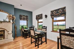 a dining room with a fireplace and a table and chairs at Carnbore House BnB in Bushmills