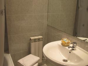 W łazience znajduje się umywalka, toaleta i lustro. w obiekcie Hotel Turmo w mieście Labuerda