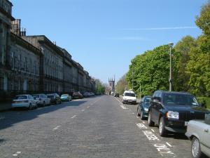 una strada con auto parcheggiate sul lato della strada di Terrace hotel a Edimburgo