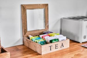 a box of tea on the floor next to a mirror at Carnbore House BnB in Bushmills