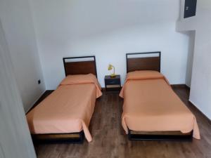 two beds in a small room with a cross at B&B Vista Mare in Palmi