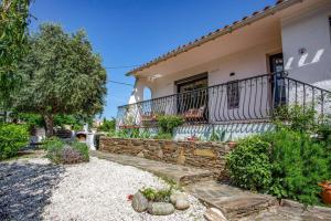 a house with a stone wall and a balcony at Villa du Soleil by Villa Plus in Laroque-des-Albères