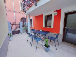a patio with a table and chairs and a red wall at Casa Orange in Koper +2 photos