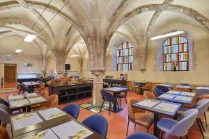 a restaurant with tables and chairs in a building at Appart'hôtel Odalys City - Dijon Centre Les Cordeliers in Dijon