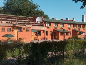 a large orange building with tables and umbrellas at Gościniec Syty Lis Agroturystyka in Starnice