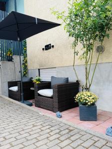a patio with chairs and an umbrella on a sidewalk at Neu renovierte Ferienwohnung mit Terrasse & schnellem WLAN im Odenwald in Fürth