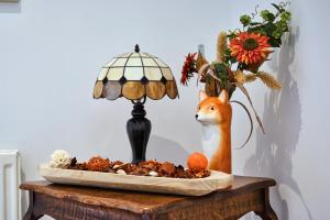 a table with a lamp and a vase with a fox at Carnbore House BnB in Bushmills